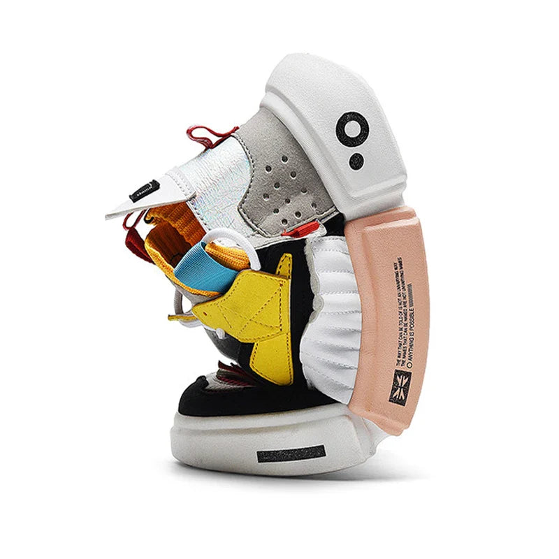 A deconstructed Extreme VS7 Sneaker with colorful sections—black, yellow, white, beige, and orange—stacked and sewn together in an abstract, sculptural form on a white background, perfect for streetwear sneaker fans.