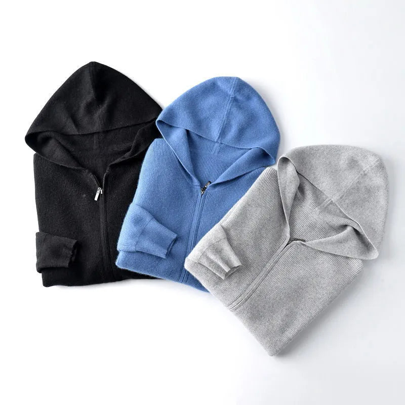 Three cashmere hoodies in black, blue, and light gray are folded neatly side by side on a white background, offering lightweight insulating warmth and softness.