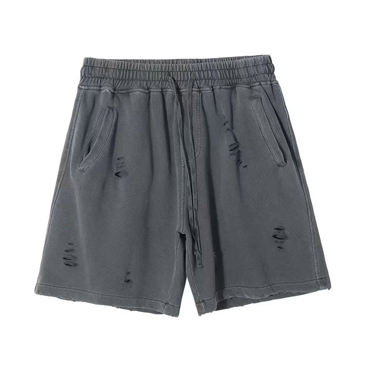 A pair of gray, vintage baggy shorts with an elastic waistband, drawstring, side pockets, and distressed details, laid flat on a white background.