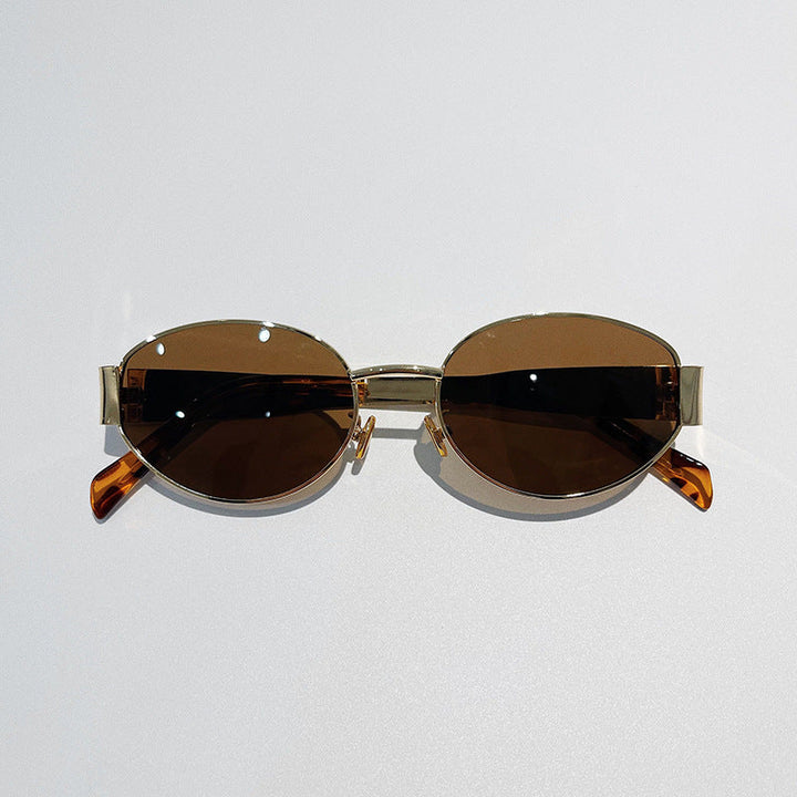 A pair of vintage-inspired sunglasses with gold frames and dark brown tinted lenses, offering Italian style and UV400 protection, displayed against a plain light background.