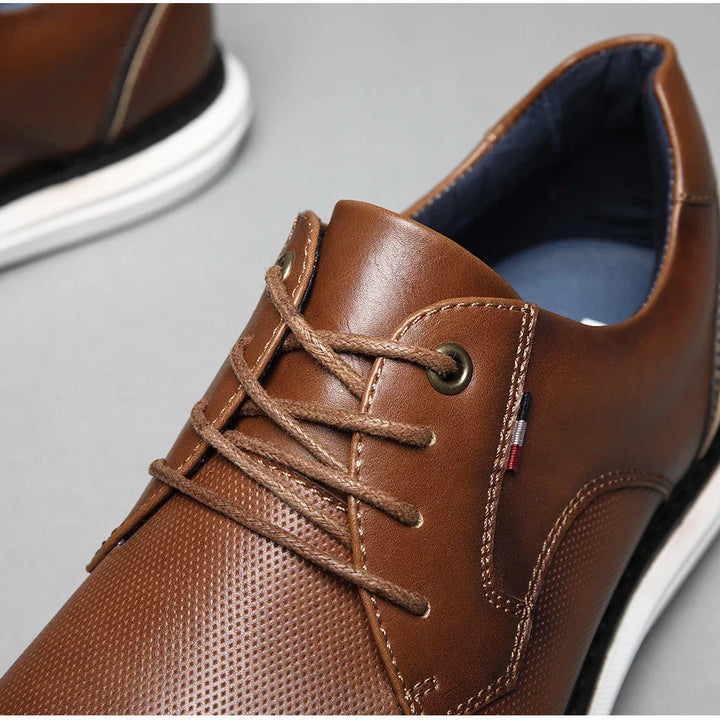 Close-up of a luxury mens shoe crafted from genuine leather, with laces and traditional detailing. Features a small striped tag, white and black sole, and blue inner lining for added style.