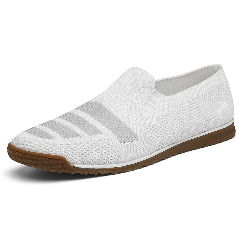 A white men’s casual loafer with a textured knit upper, subtle horizontal stripes, and a brown rubber sole. The breathable shoe features a canvas lining, low profile, and no visible laces for effortless style.