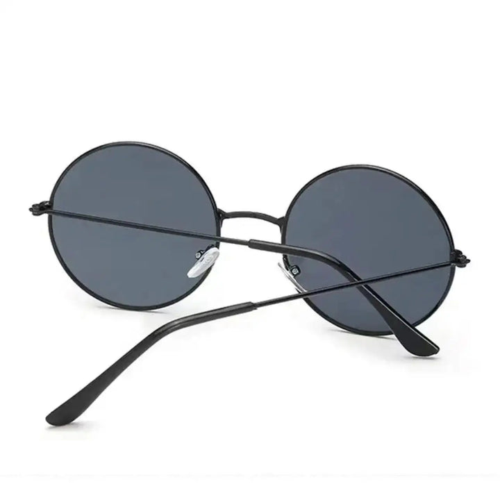 Round minimalist sunglasses with UV400 protection and dark lenses are shown from the back, temples crossed over one another against a plain white background.