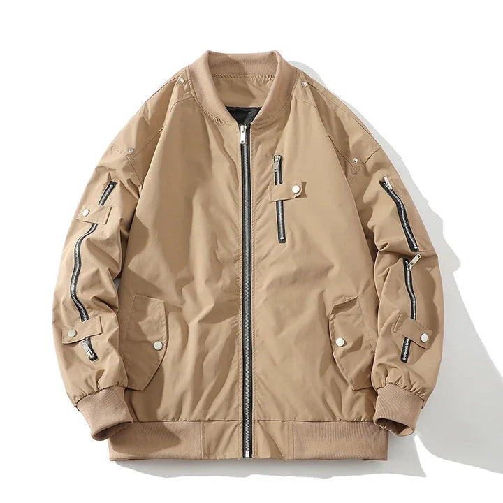 A beige bomber jacket with a classic design, featuring black zipper details on the front and sleeves, snap-button pockets, ribbed collar, cuffs, and waistband, laid flat on a white background.