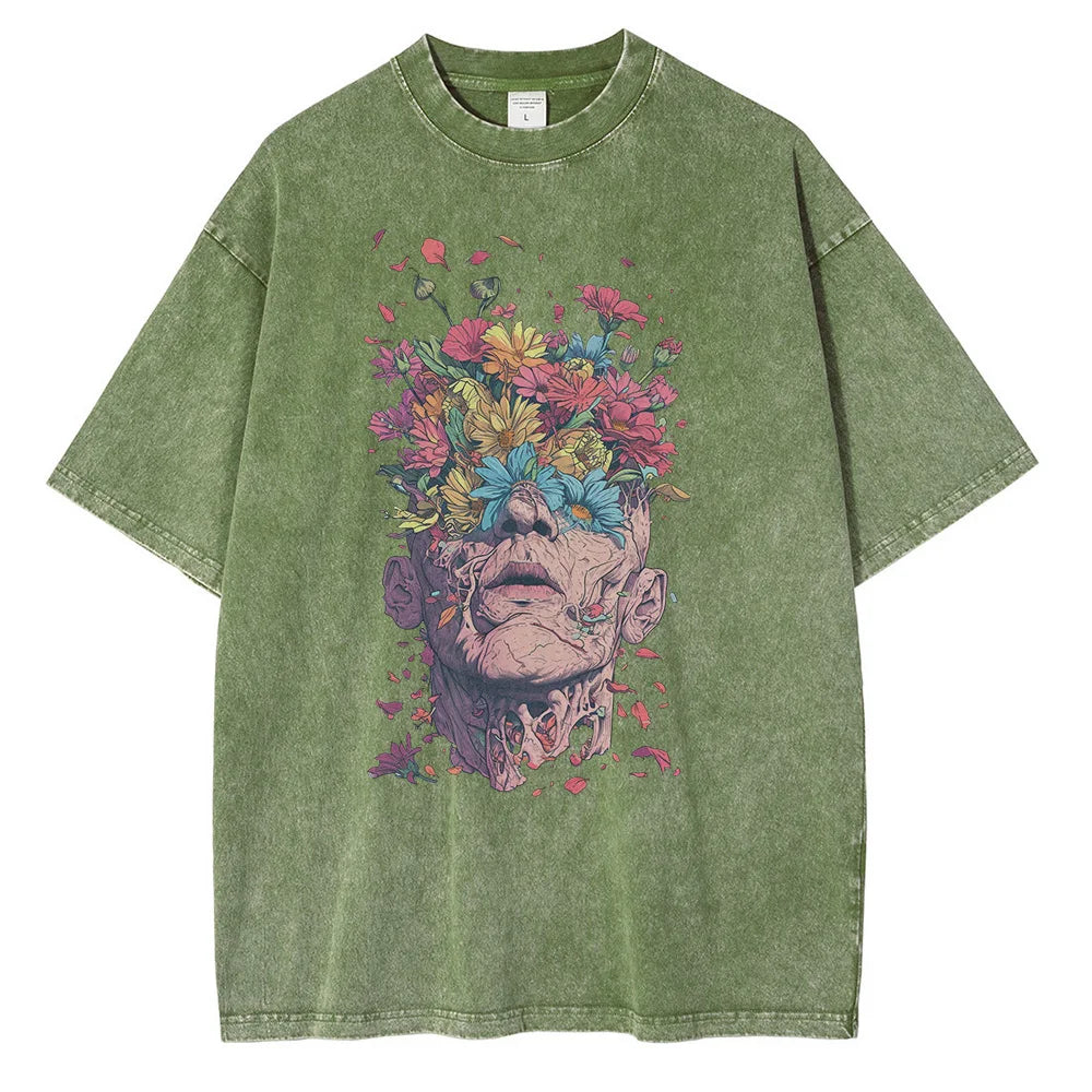 Olive green t-shirt in premium cotton with an oversized fit, featuring a striking graphic design of a human head blooming with colorful flowers and petals, blending surreal and botanical elements.