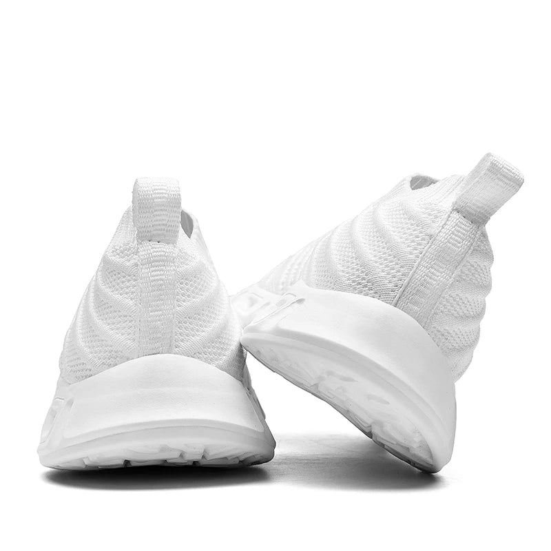 A pair of white athletic sneakers viewed from the back, with one shoe standing upright and the other slightly tilted, showcasing the textured knit and thick white cushioned soles for comfort.