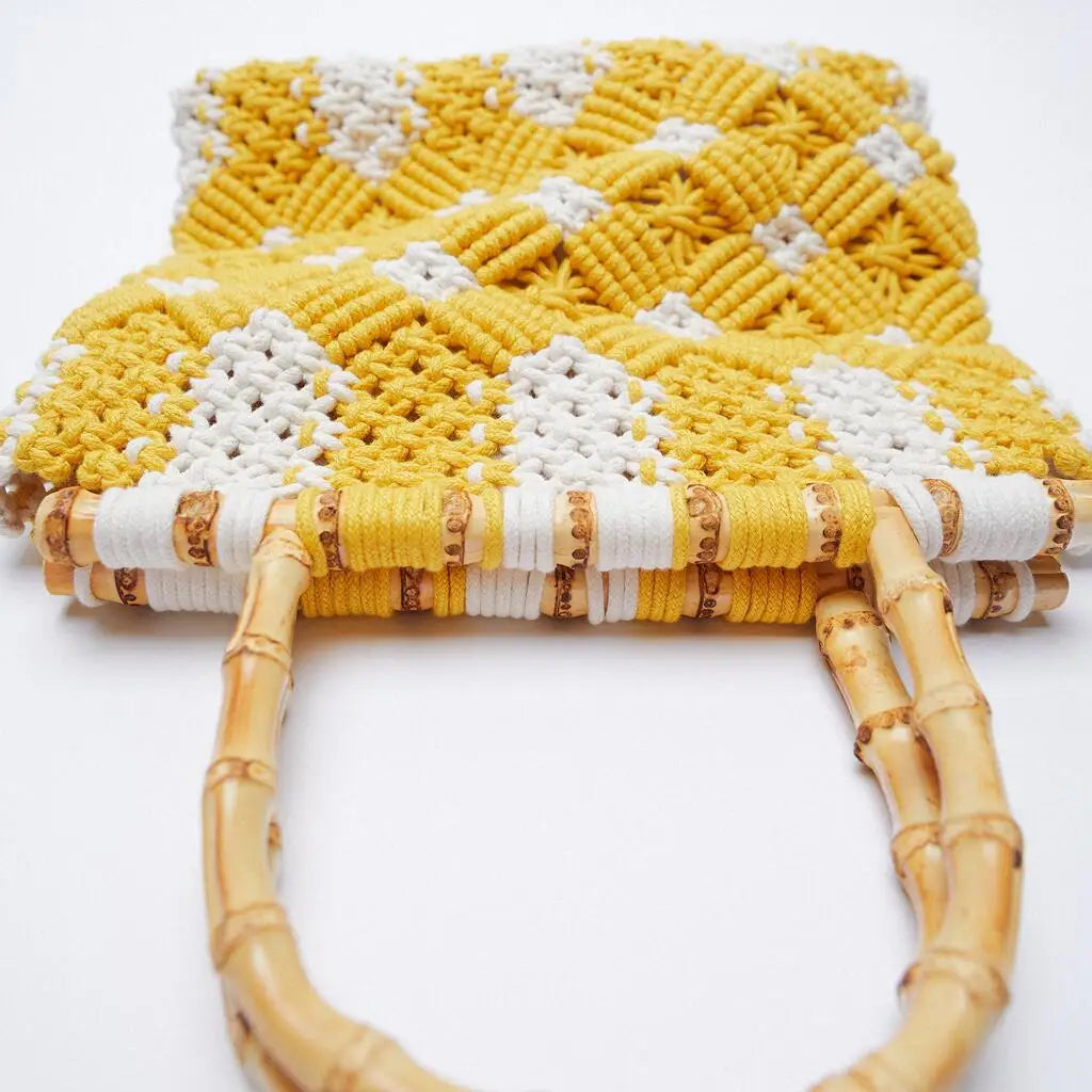 A close-up of a lightweight bag with a yellow and white diamond pattern and curved bamboo handles, set against a white background.