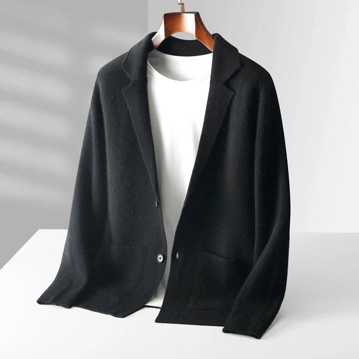 A black business casual cardigan with two front pockets is displayed on a hanger over a plain white t-shirt, set against a minimal, light gray background—perfect as an autumn winter knit cardigan for effortless style.