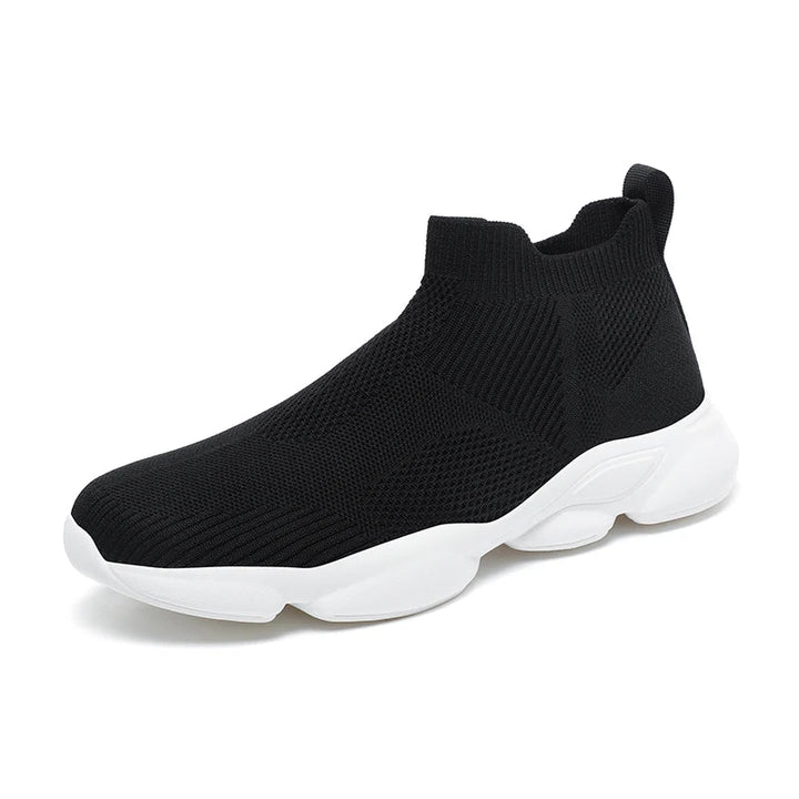 A black slip-on athletic shoe with a white, thick non-slip sole, featuring a lightweight, breathable knit fabric upper and a pull-tab at the heel.
