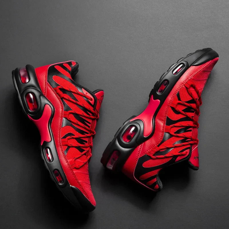 A pair of stylish red and black athletic sneakers with a breathable mesh upper, bold patterns, and black soles, displayed on a dark background.