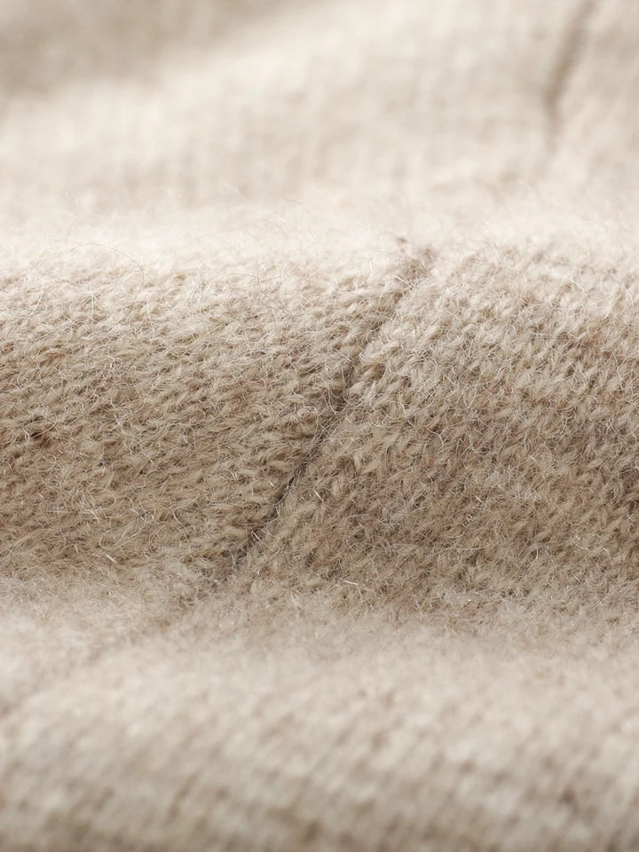 Close-up of a beige knit cardigan, highlighting its soft, fuzzy texture and detailed stitching—perfect for an autumn winter cardigan.