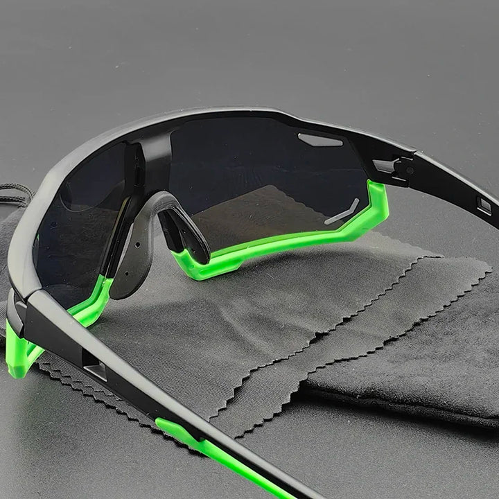 Sporty Olympus Sunglasses with black frames and neon green accents rest on a gray cleaning cloth, against a plain dark background. The slightly reflective, dark tinted lenses offer reliable UV protection.