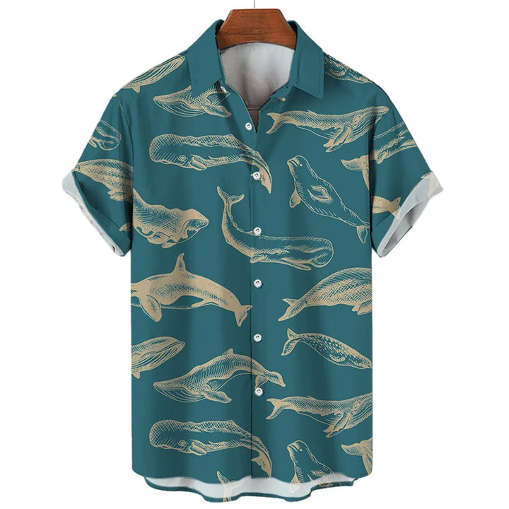 A teal short-sleeve button-up shirt with a pattern of beige whales and other large sea creatures illustrated across the fabric. Ocean-inspired and summer-ready, this shirt hangs on a wooden hanger.