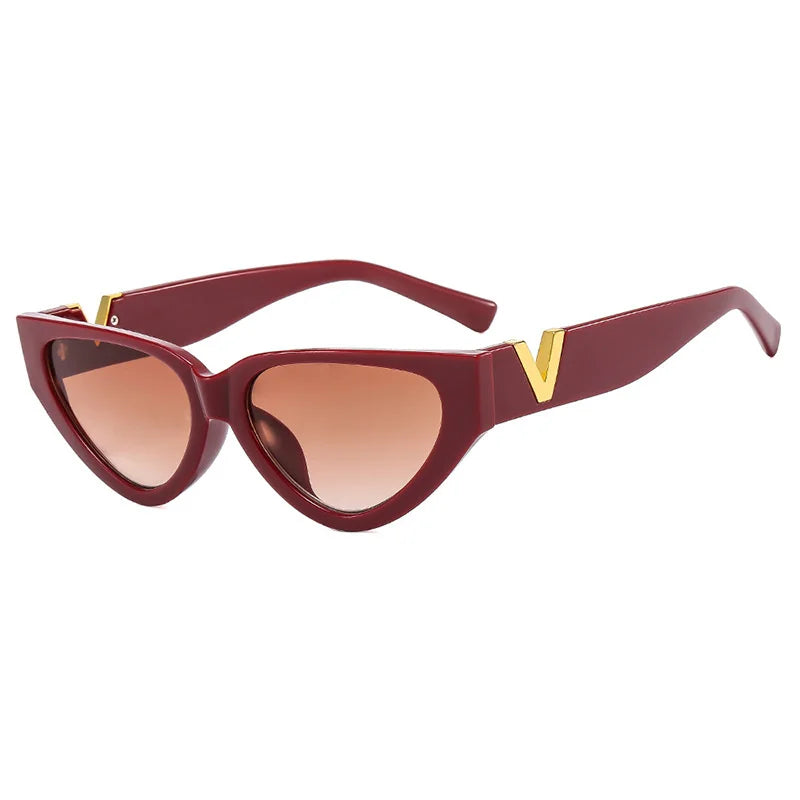 Red vintage cat eye sunglasses with bold frames, gradient brown lenses, UV400 protection, and gold V accents on the corners and arms, displayed on a white background.