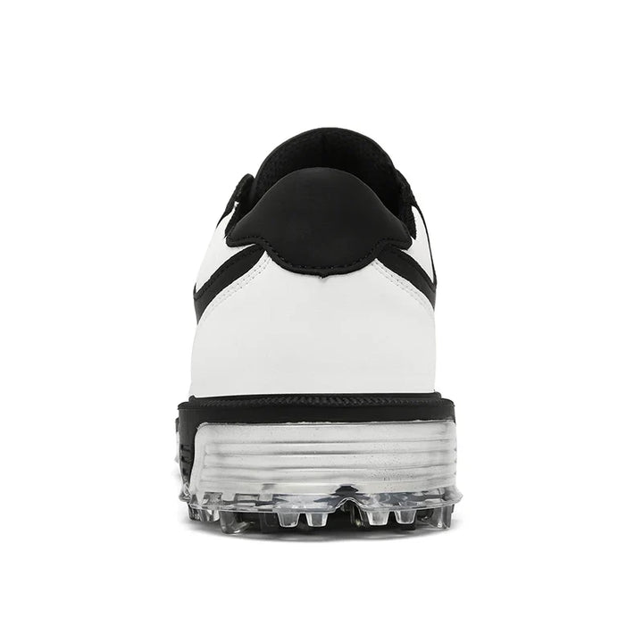 Rear view of a white sneaker with a black heel, black accents, and a transparent sole featuring visible studs and a high-traction outsole, set against a plain white background.
