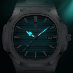 A close-up of a stainless steel wristwatch with a dark face, luminous hour and minute hands glowing blue-green, quartz movement, and a date window at 3 o’clock. The dim background emphasizes the glowing hands.