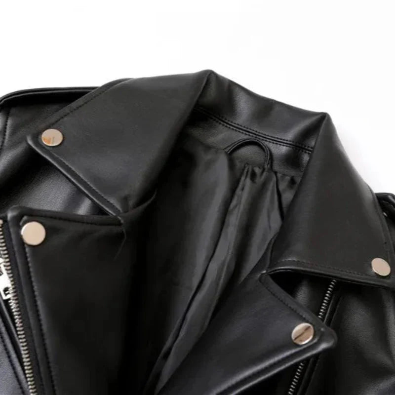 Close-up of a black leather jacket with silver snap buttons, a visible zipper, and an adjustable waist belt, laid open on a white background.