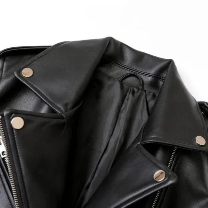 Close-up of a black leather jacket with silver snap buttons, a visible zipper, and an adjustable waist belt, laid open on a white background.
