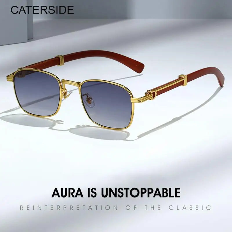 A pair of gold-rimmed square retro sunglasses with brown arms and blue-tinted UV protection lenses rests on a light surface. Text reads “CATERSIDE,” “AURA IS UNSTOPPABLE,” and “REINTERPRETATION OF THE CLASSIC.”.