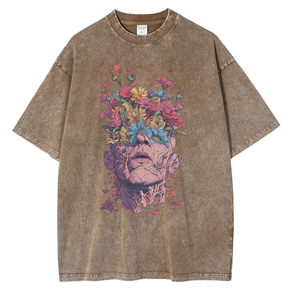 A brown, oversized fit T-shirt crafted from premium cotton, featuring a graphic design of a human head with vibrant flowers blooming from the top, blending surreal and botanical elements across the chest.