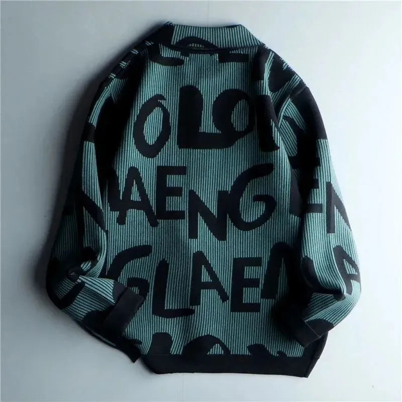 A teal and black sweater with large, bold, abstract letters in a random, overlapping pattern, displayed flat with sleeves slightly folded inward—a stylish Korean loose fit reminiscent of a vintage knitted cardigan.