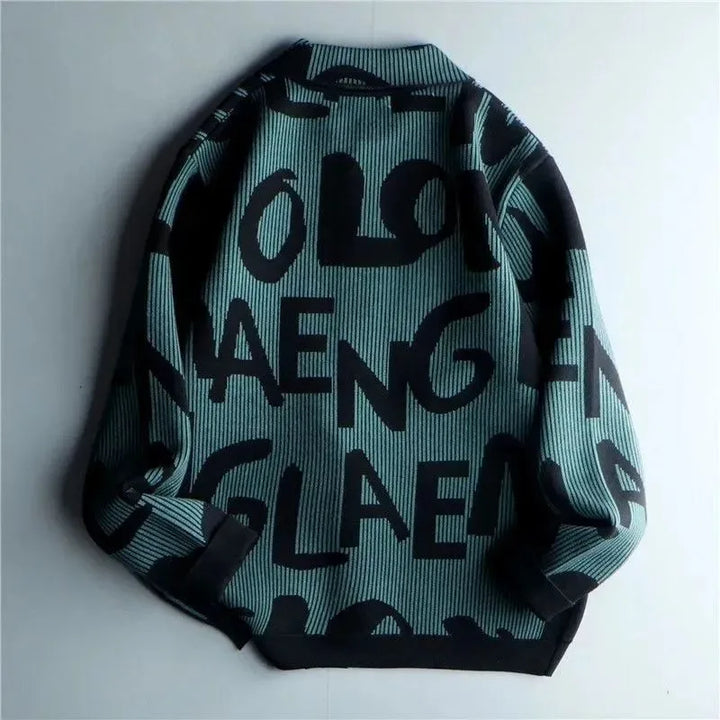 A teal and black sweater with large, bold, abstract letters in a random, overlapping pattern, displayed flat with sleeves slightly folded inward—a stylish Korean loose fit reminiscent of a vintage knitted cardigan.