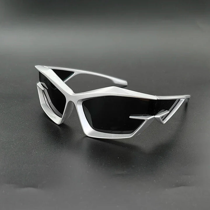 Futuristic silver sunglasses with angular, geometric frames and high-contrast lenses offering UV400 protection, displayed on a matte black surface.