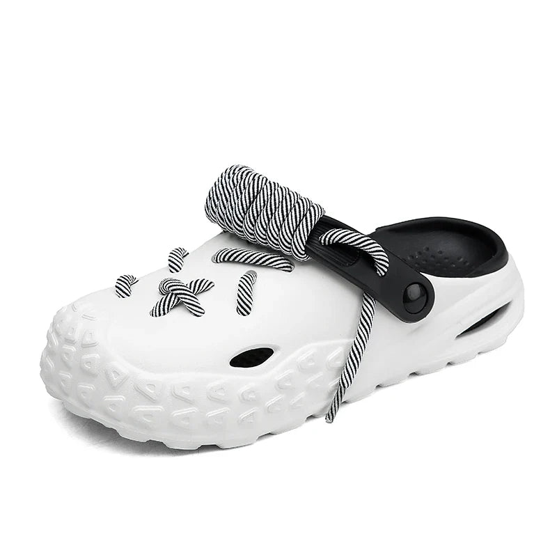 A white slip-on clog with a textured sole for enhanced grip, black interior, black back strap, and black-and-white striped lace detail threaded through holes on the top.