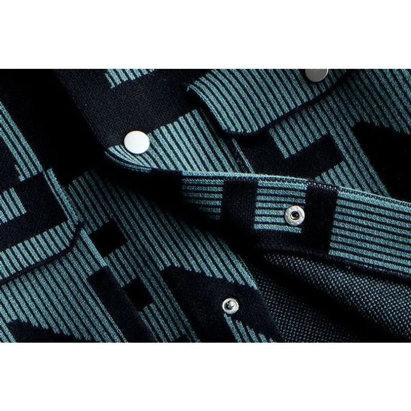 Close-up of a mens long sleeve coat in dark blue and teal patterned fabric with metal snap buttons, featuring geometric designs and striped details for a touch of Korean loose fit style.