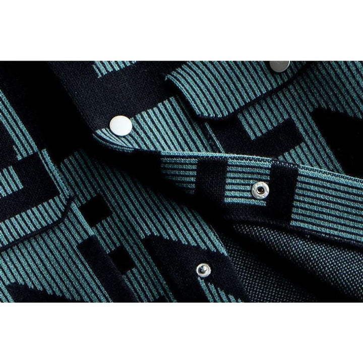 Close-up of a mens long sleeve coat in dark blue and teal patterned fabric with metal snap buttons, featuring geometric designs and striped details for a touch of Korean loose fit style.