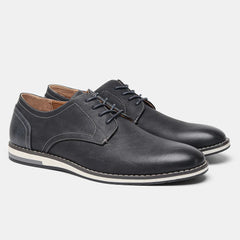 A pair of black leather patchwork oxfords with white stitching and contrasting white and gray cushioned soles, displayed on a plain light background.
