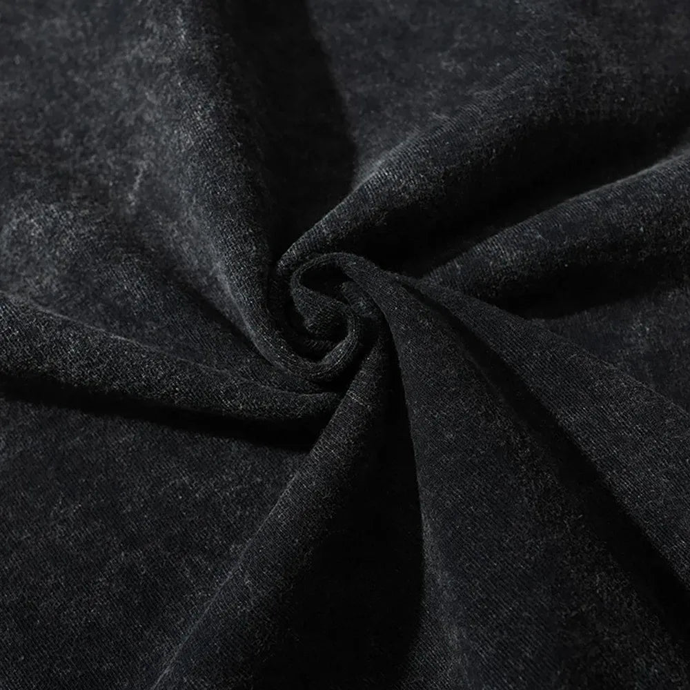 Close-up of black velvet fabric with a soft, slightly shiny texture, gathered and twisted in the center to create gentle folds and a spiral pattern—perfect inspiration for graphic design projects.