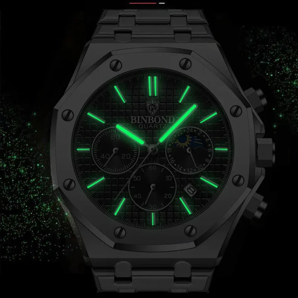 A black BINBOND stainless steel watch with a textured dial, green luminous hands and markers, chronograph dials, and a date window glows in the dark against a black background with green speckles.