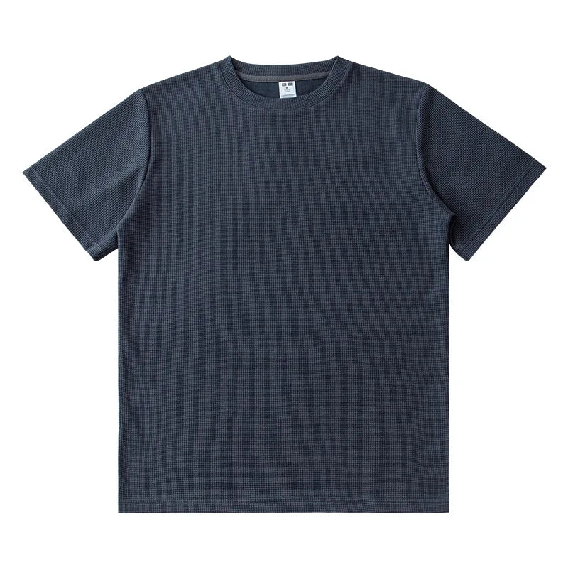 A plain, short-sleeved, dark gray crew neck t-shirt is laid flat on a white background. Featuring a subtle waffle knit texture, this heavyweight shirt has no visible logos or designs.