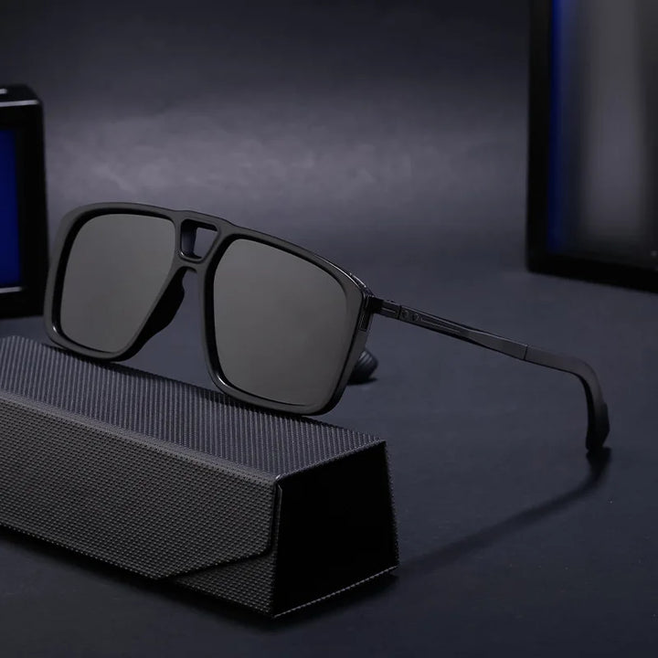 A pair of black rectangular polarized sunglasses with dark lenses rests on a textured black case against a dark, softly lit background, offering style and UV protection.