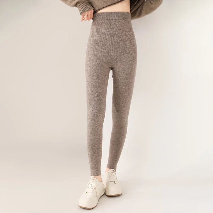 A person wearing high-waisted, breathable knit leggings in taupe and white sneakers poses against a plain, light background. Their upper body is mostly out of frame.