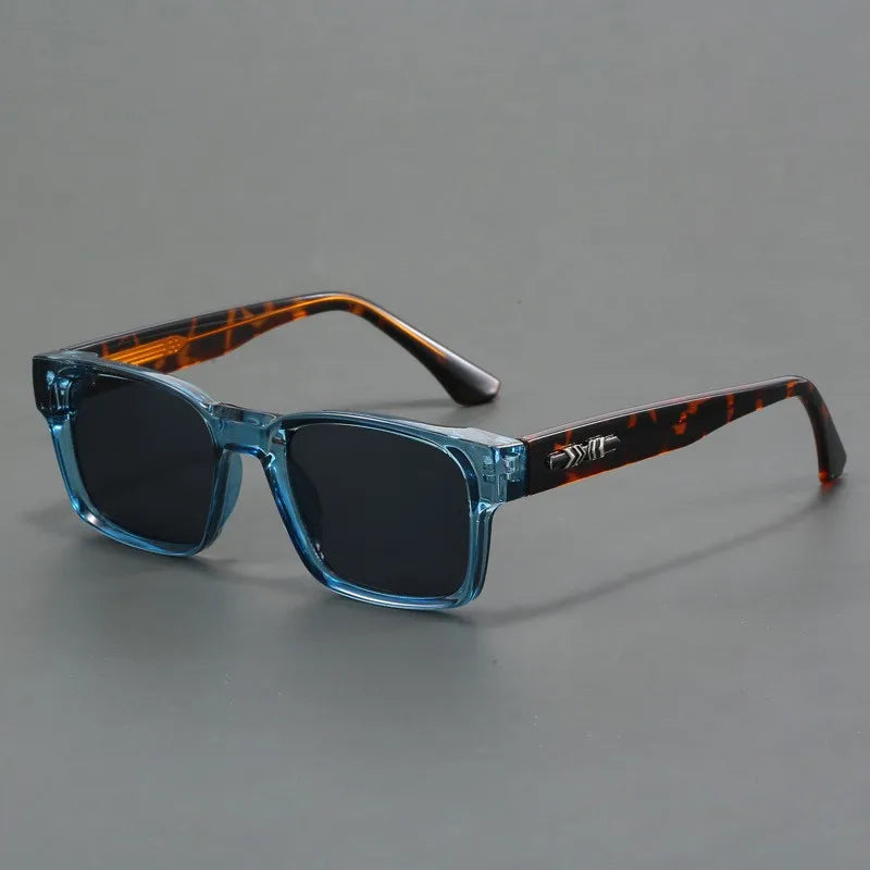 A pair of sunglasses with translucent blue square frames and dark lenses feature durable frames; the temples are brown with a tortoiseshell pattern and black tips, all set against a plain gray background.