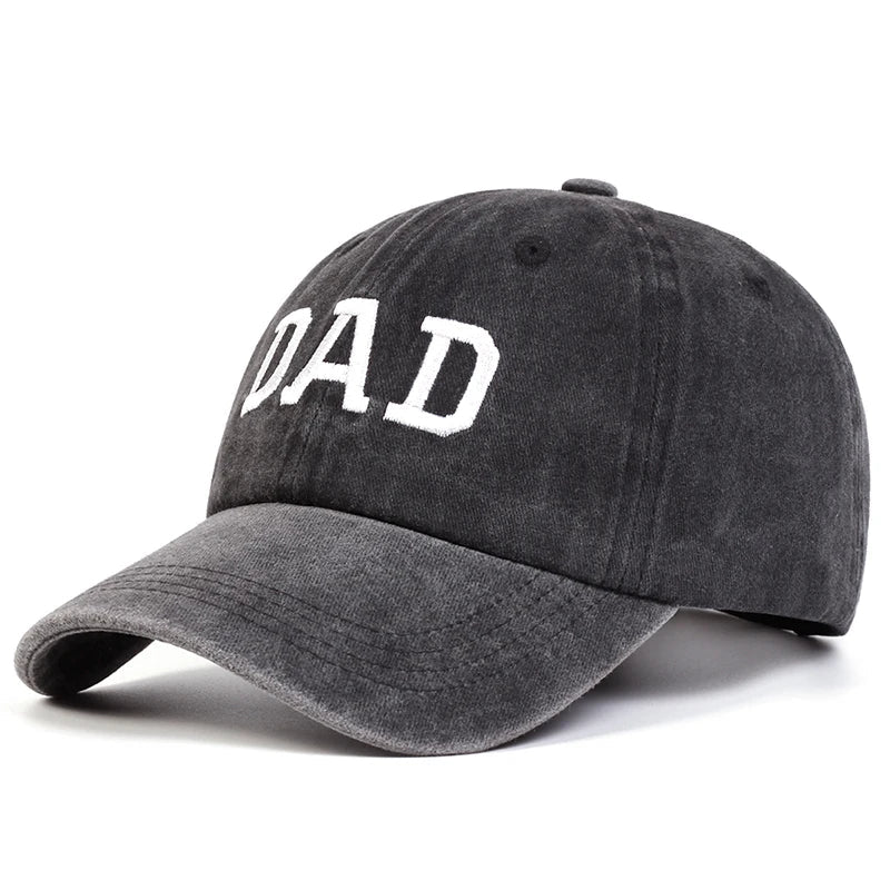 A dark gray embroidered cap with the word DAD in large white letters on the front, inspired by vintage streetwear and perfect as a classic Mom & Dad cap.