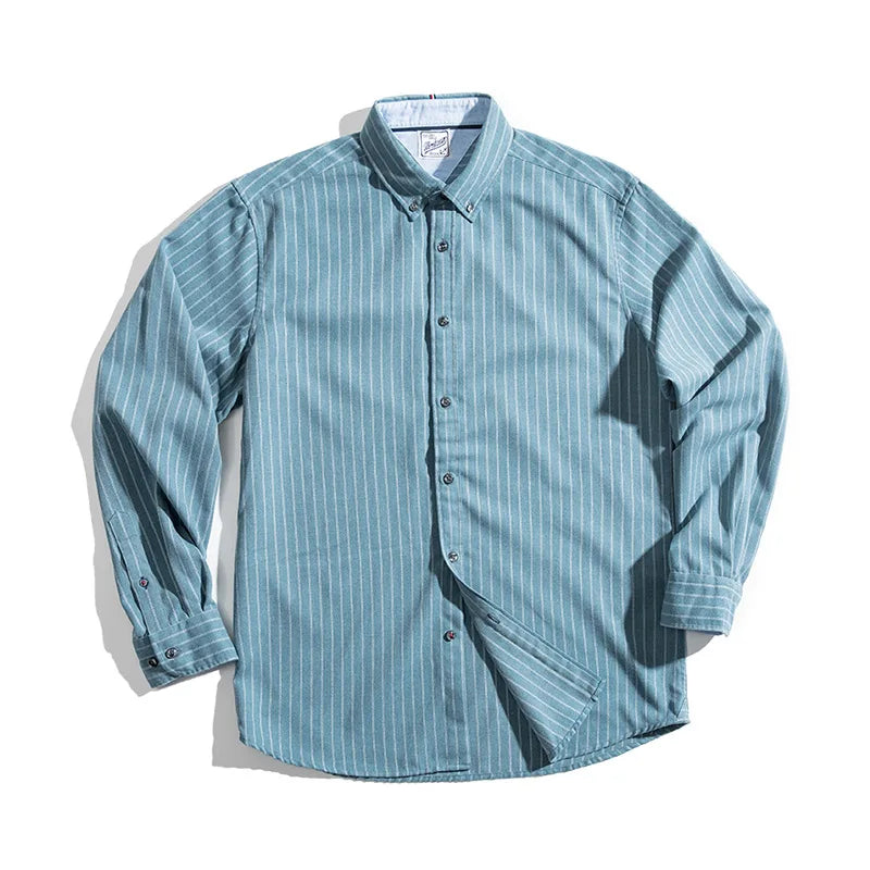 A long-sleeved, button-up pinstripe shirt with a collar in a blue-green color featuring vertical white stripes, made from fine weave cotton and laid flat on a white background.