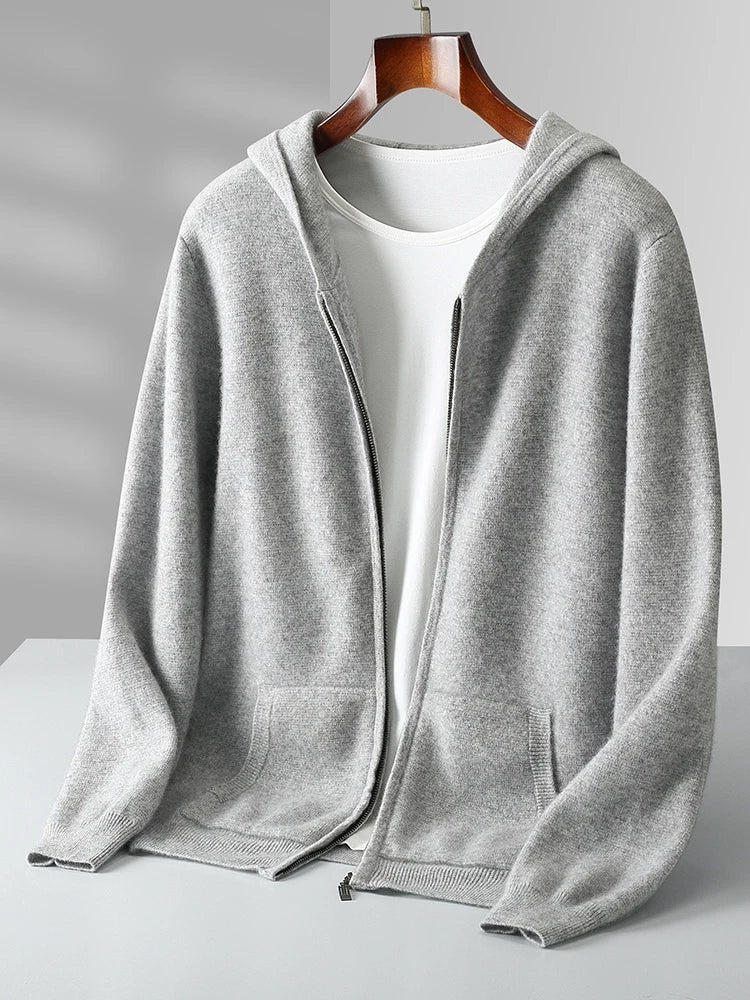 A light gray zip-up hoodie with a hood and front pockets, styled like an autumn winter cardigan, is displayed on a wooden hanger over a plain white T-shirt against a neutral background.
