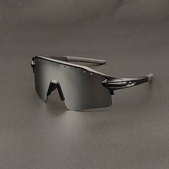 Futuristic, black oversized sunglasses with a single wraparound mirrored lens and sleek, angular frames, featuring UV400 protection, displayed on a gray surface.