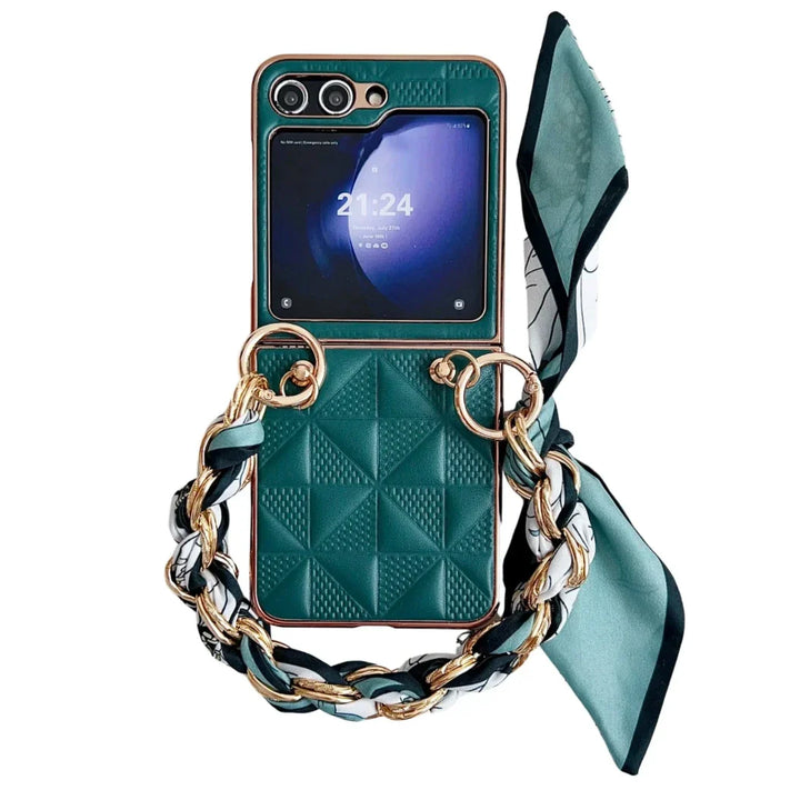 A green quilted premium leather case with a gold and green chain handle, accented by a patterned scarf. Designed for the Samsung Galaxy Z Flip, this chic case offers stylish shockproof protection while displaying the time, 21:24, on screen.