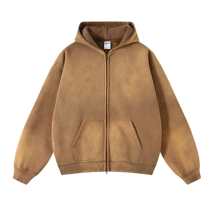 A brown zip-up hoodie with a front pocket and hood, featuring a slightly faded, spray-dyed vintage look. Made from thickened fabric, the relaxed fit style is laid flat on a white background.