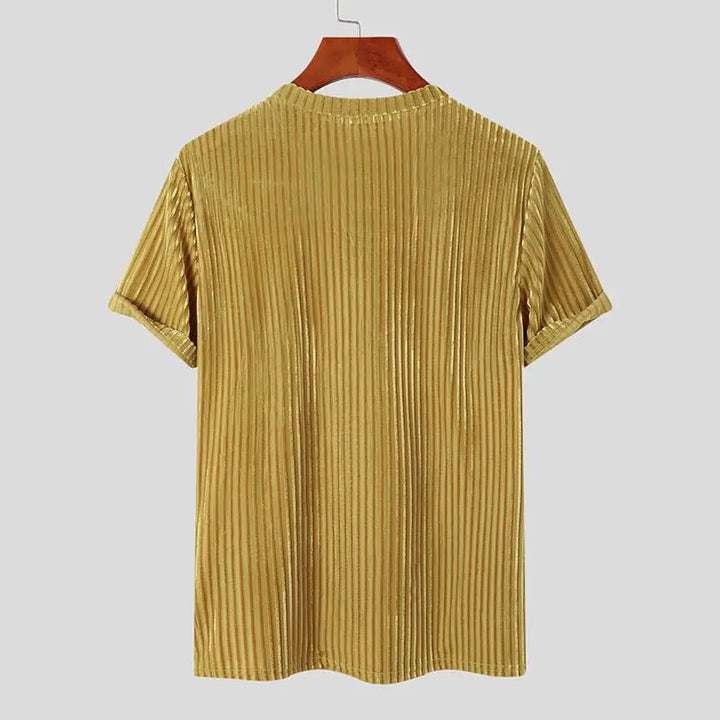 A gold-colored, short-sleeve, stripe corduroy tee in a classic fit is displayed on a wooden hanger against a plain light gray background. The ribbed velvet shirt is shown from the back.