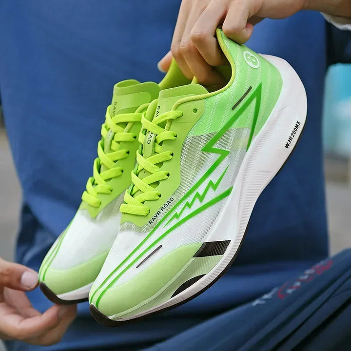 A person holds a pair of neon green and white running shoes with lightning bolt designs and bright green laces. Featuring shock-absorbing sole, the sporty shoes are lightweight, and the person is dressed in blue clothing.