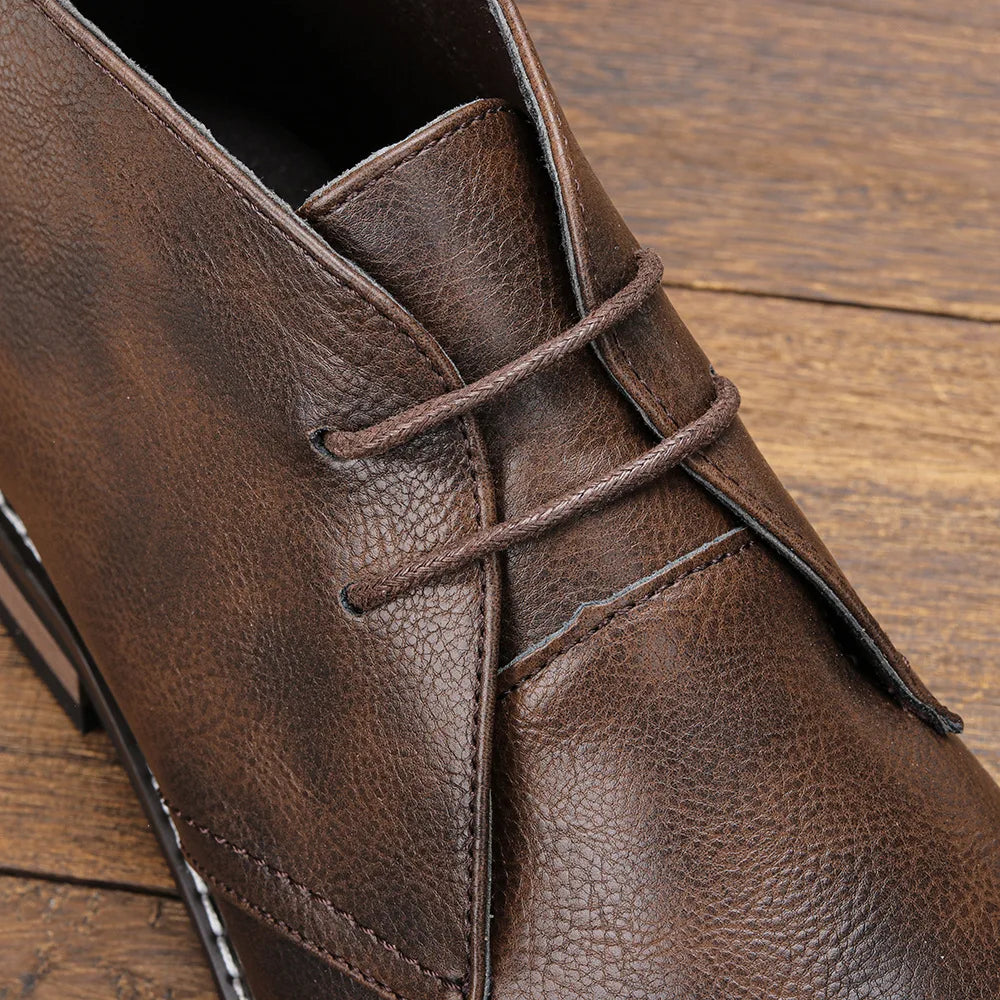 Close-up of a Western-inspired chukka on a wooden surface, highlighting the rich leather texture and detailed stitching.