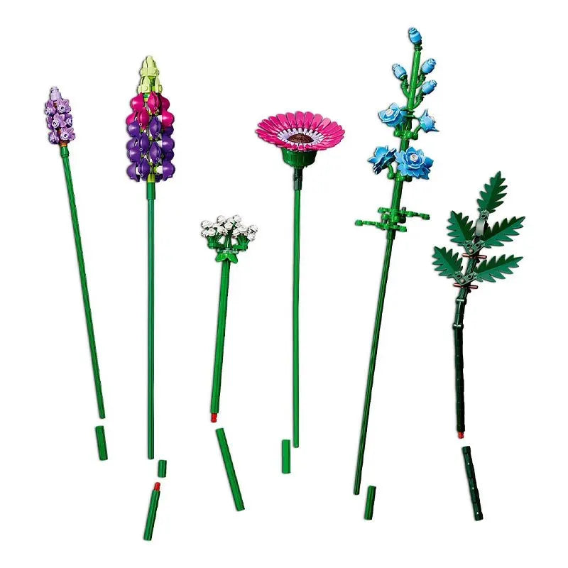 Six LEGO flowers with green stems and colorful petals in purple, pink, blue, and white, create a vibrant Wildflower Bouquet using playful building blocks, arranged upright against a white background.