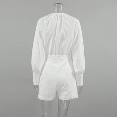 A clear mannequin displays a chic romper—white, long-sleeve, with an elastic waist and cuffed sleeves—shown from the back against a plain gray background. Perfect for a stylish summer outing.