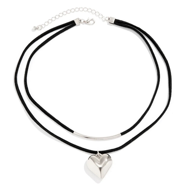 A double-layer black cord necklace features a silver metal curved bar on the upper layer and a vintage heart pendant on the lower, finished with an adjustable choker clasp for the perfect fit.