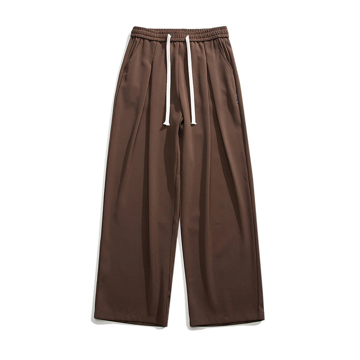 Wide-leg brown GOAT Joggers with an elastic waistband and white drawstrings, laid flat on a white background. These streetwear joggers feature side pockets and a relaxed, casual fit for everyday comfort.